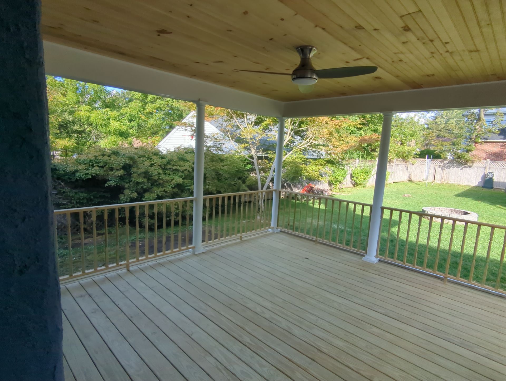 Screened porch addition with architectural columns and custom-framed invisible screening